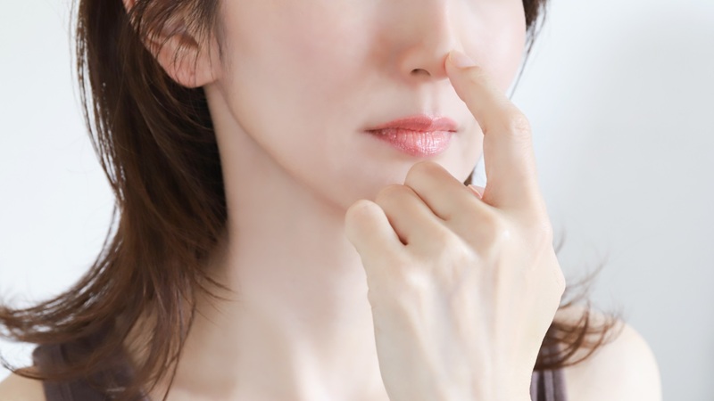鼻を触る女性